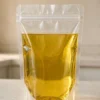 透明自立食用油包装袋装满金黄色食用油，带压合拉链与窄顶封边，立在厨房台面上